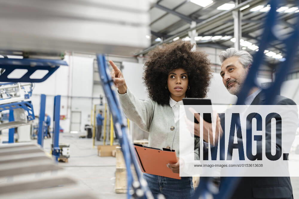 IMAGO Creative: Business, Inflation und Lieferketten Technician showing machine to businessman with tablet PC in factory model released property released, JCCMF05539