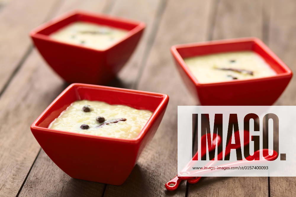 Three red bowls of the Ecuadorian dessert called morocho (coarsely ground white corn) cooked with milk, sugar and spices (cinnamon and allspice), similarly to rice pudding (Selective Focus, Focus on the middle of the lower morocho) , 14343508.jpg, morocho, cooked, sweet, dessert, pudding, food, milk, spice, condiment, cinnamon, allspice, newspice, Jamaica pepper , prepared, Ecuador, Ecuadorian, traditional, corn, maize, ground, coarse, kernel, porridge, bowl, red, horizontal, white,