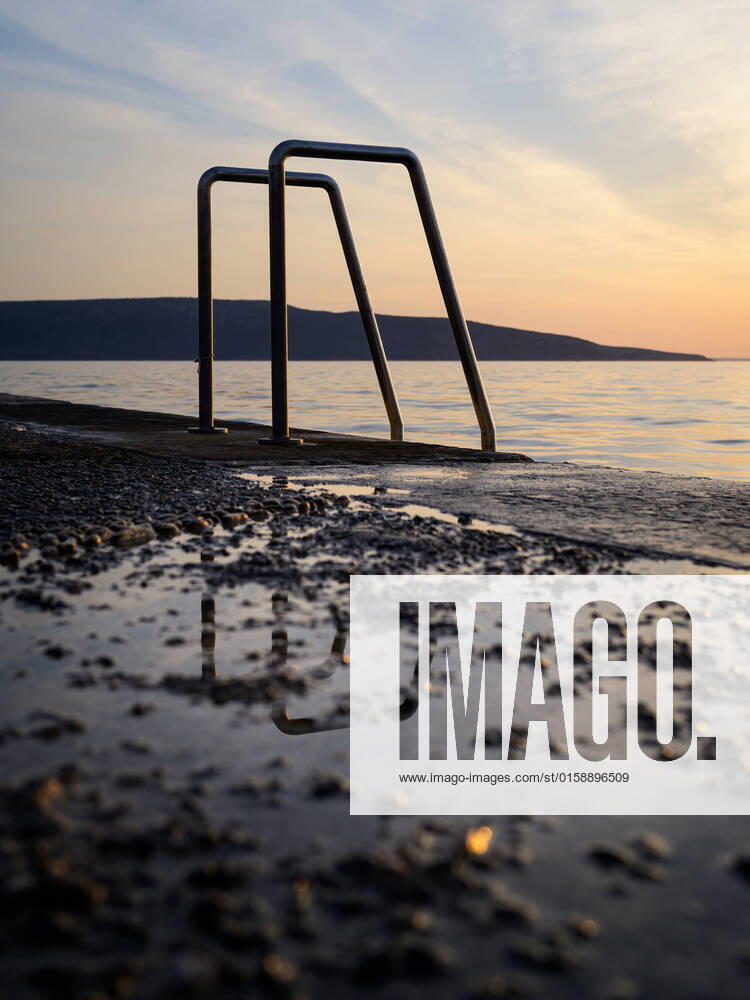 IMAGO Creative: 2022 Favoriten IMAGO Creative: Sommer Sport - Strand Ladder into the sea at the beach in Cres (Croatia), sunset in springtime, reflections in puddle Cres Croatia
