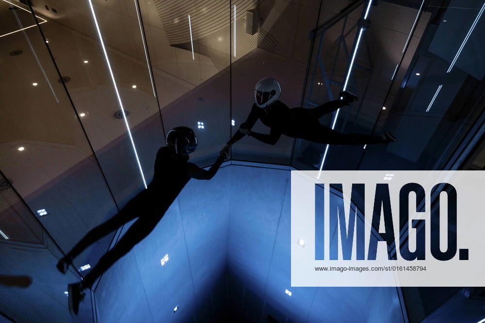 IMAGO Creative: Business, Innovative Technologie-Lösungen Athletes holding each others hands flying in illuminated wind tunnel model released, Symbolfoto property released, MRRF02117