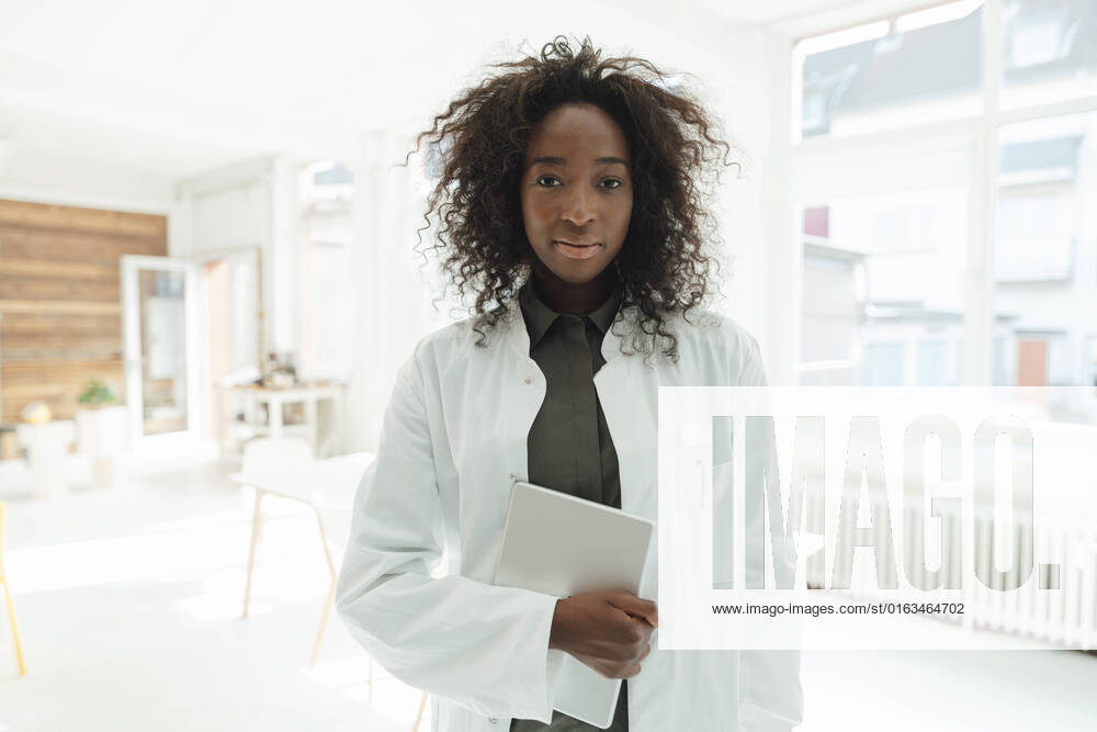 IMAGO Creative: Business, Innovative Technologie-Lösungen Female doctor with curly hair holding tablet PC model released, Symbolfoto property released, KNSF09407
