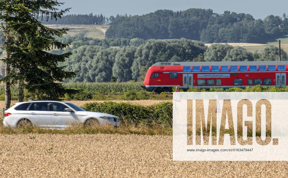 Car and regional train in the countryside, on the road in the district of Landshut,