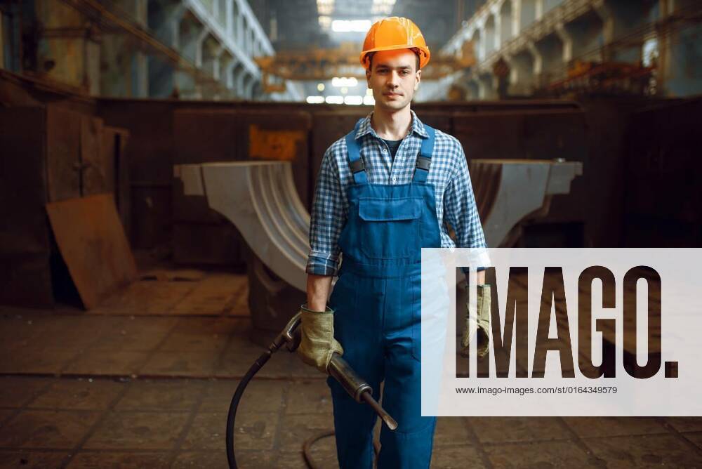 IMAGO Creative: Business, Inflation und Lieferketten Male worker holds pneumatic jackhammer on factory, Male worker in uniform and helmet holds pneumatic jackhammer on factory. Metalworking industry, industrial manufacturing of steel products, Male worker in uniform and helmet holds pneumatic jackhammer on factory. Metalworking industry, industrial manufacturing of steel products model released, Symbolfoto , 04.03.2020,