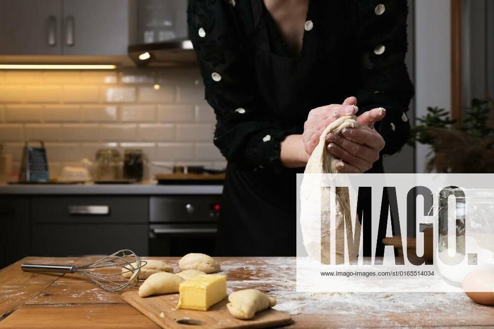 Young beautiful woman kneading dough at a wooden table in kitchen. Housewife hobbies concept., Young beautiful woman kneading dough at a wooden table in kitchen. Housewife hobbies concept. model released, Symbolfoto , 06.12.2020,