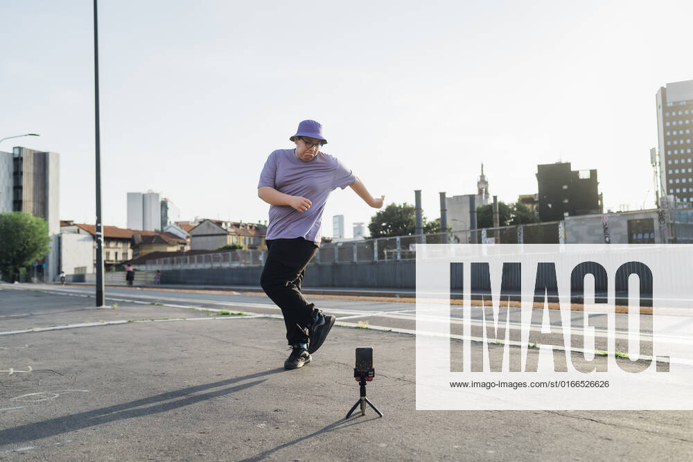 Teenage boy recording dancing video on smart phone at street model released, Symbolfoto, MEUF07396