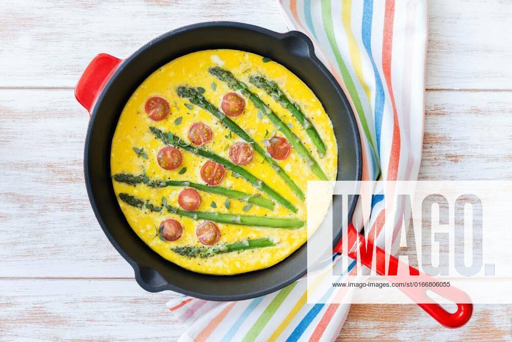 Frittata with fresh asparagus and cherry tomatoes. Top view, Top view of freshly made frittata with green asparagus and cherry tomatoes in a frying pan, Top view of freshly made frittata with green asparagus and cherry tomatoes in a frying pan, 22.04.2021,
