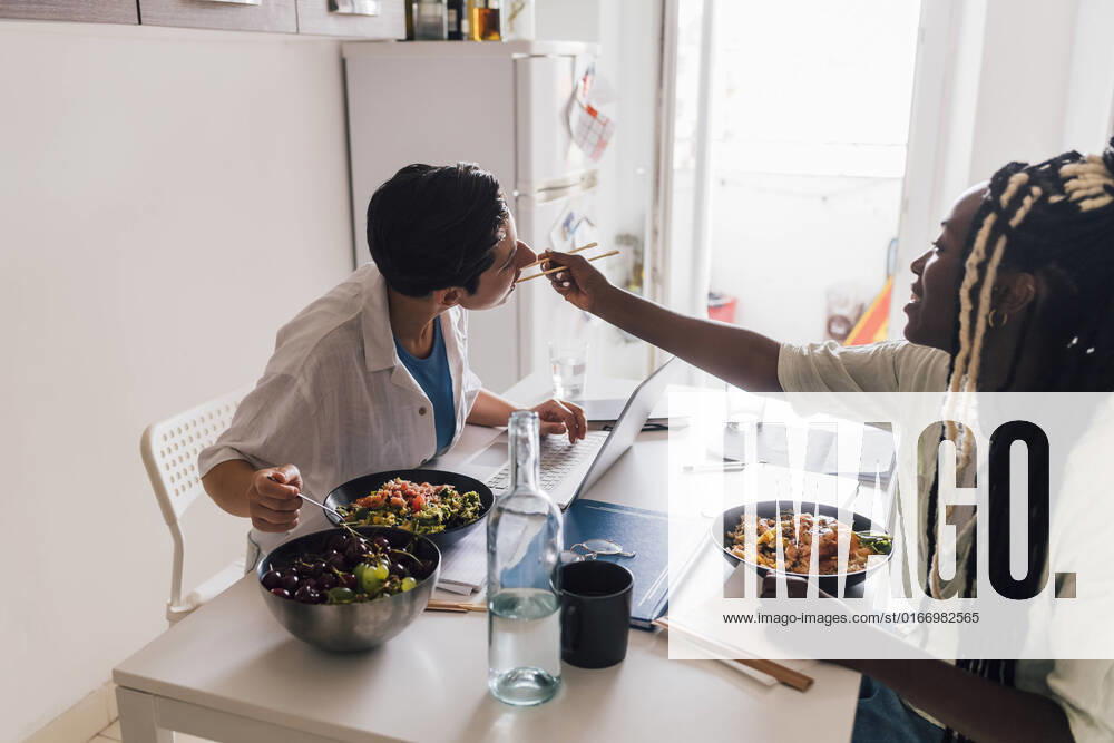 Young businesswoman feeding poke to girlfriend at home model released, Symbolfoto property released, MEUF07919