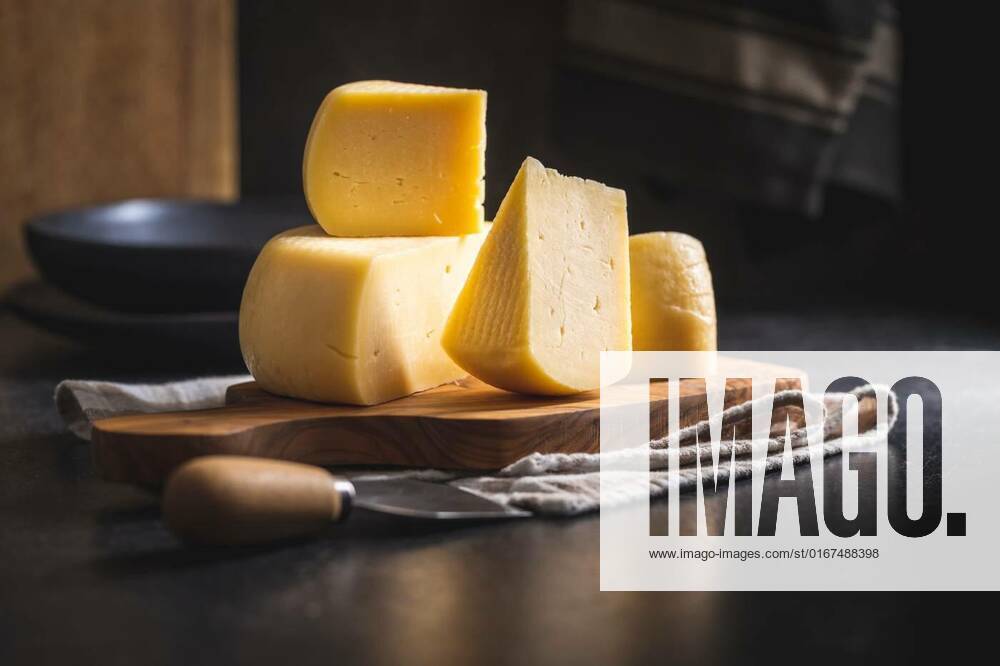 Block of hard cheese. Sliced cheese., Block of hard cheese. Sliced cheese on cutting board., Block of hard cheese. Sliced cheese on cutting board., 15.10.2021,