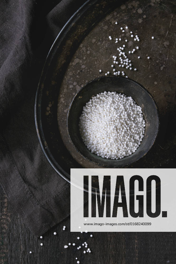 IMAGO Creative, Food, Tapioka Uncooked tapioca pearls Healthy superfood. Uncooked tapioca pearls in balck iron bowl on vintage iron tray over dark old wooden background with textile napkin. Top view.