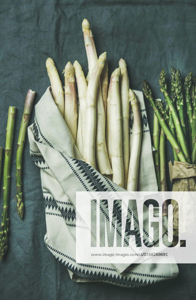 Fresh green and white asparagus in towel over dark grey linen table cloth background Fresh green and white asparagus in towel over dark grey linen table cloth background, top view