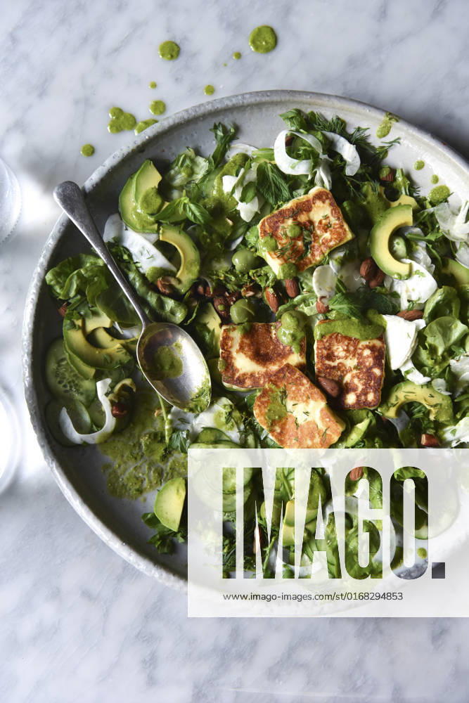 Green Salad with halloumi and dressing in a ceramic bowl. Green Salad with halloumi and dressing in a ceramic bowl.