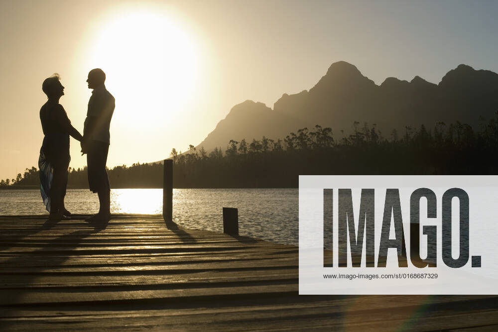 Senior Couple Standing On Edge Of Pier, model released, , property released, , 10007702.jpg, Adult, Baby Boomer, Cape Town, Caucasian, Countryside, Couple, Dock, Edge, Enjoying, Female, Happy, Holding Hands, Horizontal, Idyllic, Jetty, Lake, Leisure, Lensflare, Lourensford, Love, Male, Man, Men, Middle Age, Mountain, Nature, Outdoors, People, Person, Pier, Recreation, Relaxation, Retirement, Rural, Scenic, Side View, Silhouette, South Africa, Standing, Summer, Sunlight, Sunset, Togetherness, Two, Vacation, Water, Weekend, Woman, Women, 50s,