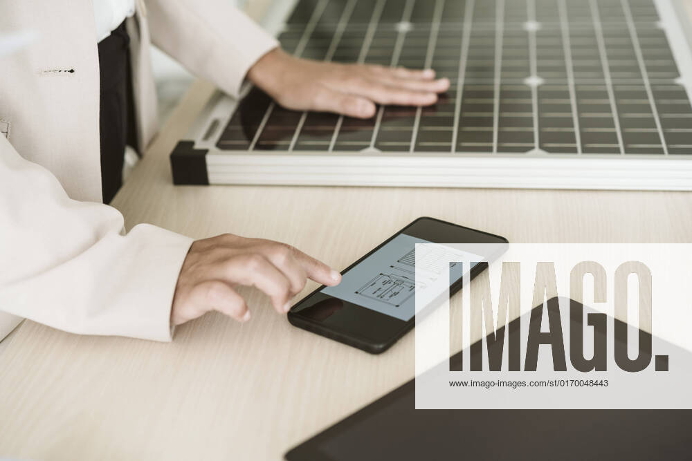 IMAGO Creative: Business, Innovative Technologie-Lösungen Close-up of woman using mobile phone with solar panel on desk model released, Symbolfoto property released, EBBF06263