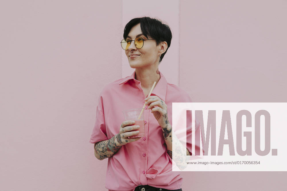 Smiling woman wearing eyeglasses holding glass standing in front of wall model released, Symbolfoto property released, OIPF02340