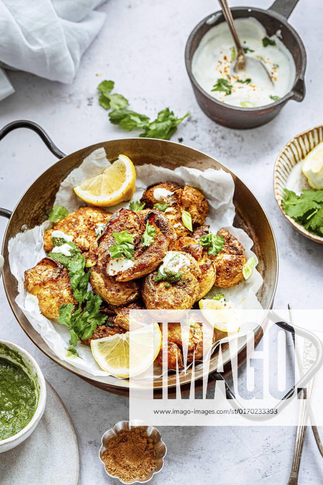 A serving platter with curried indian mashed potatoes, garnished with coriander leaves and lemon A serving platter with curried indian mashed potatoes, garnished with coriander leaves and lemon