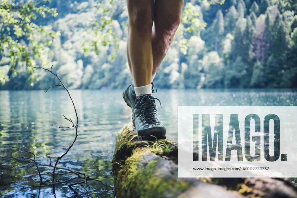 Woman wearing hiking boot walking on tree log by Lake Levico model released, Symbolfoto, GIOF15589