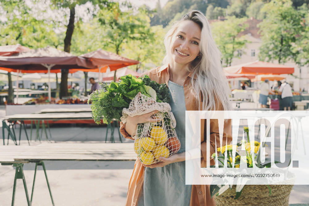 Smiling woman with fresh vegetables in mesh bag at market model released, Symbolfoto, NDEF00010