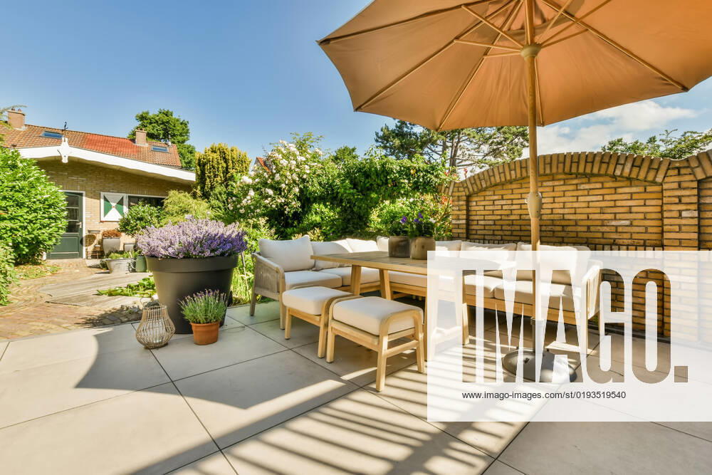 Terrace of a house with a sofa and umbrella under a blue sky with clouds, Property released ProCreators_ID664_24382_011