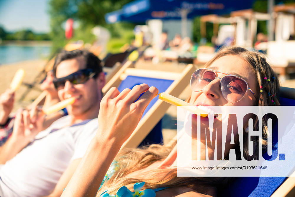 IMAGO Creative, Jahreszeit Sommer, Sommer in der Stadt Woman and man eating ice cream on beach, model released, , 36324772.jpg, Beach, Water, Woman, ice, ice cream, beach bar, man, sun lounger, couple, bar, vacation, getaway, holiday, leisure, summer, sun, sand, city beach, club, happy, relaxing, eating, lake, people, Caucasian