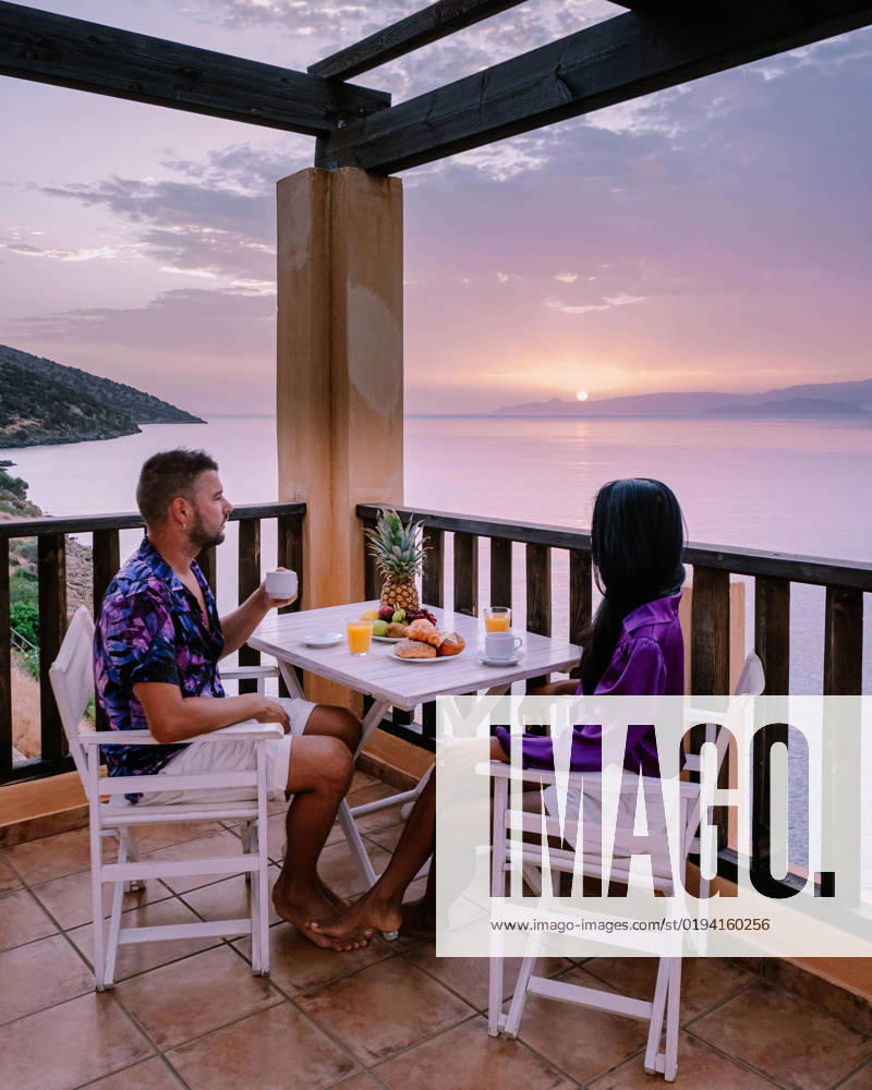 Table and chairs with breakfast during sunrise at the meditarian sea in Greece table and chairs with breakfast during sunrise at the meditarian sea in Greece. Couple having breakfast on balcony looking out over the ocean