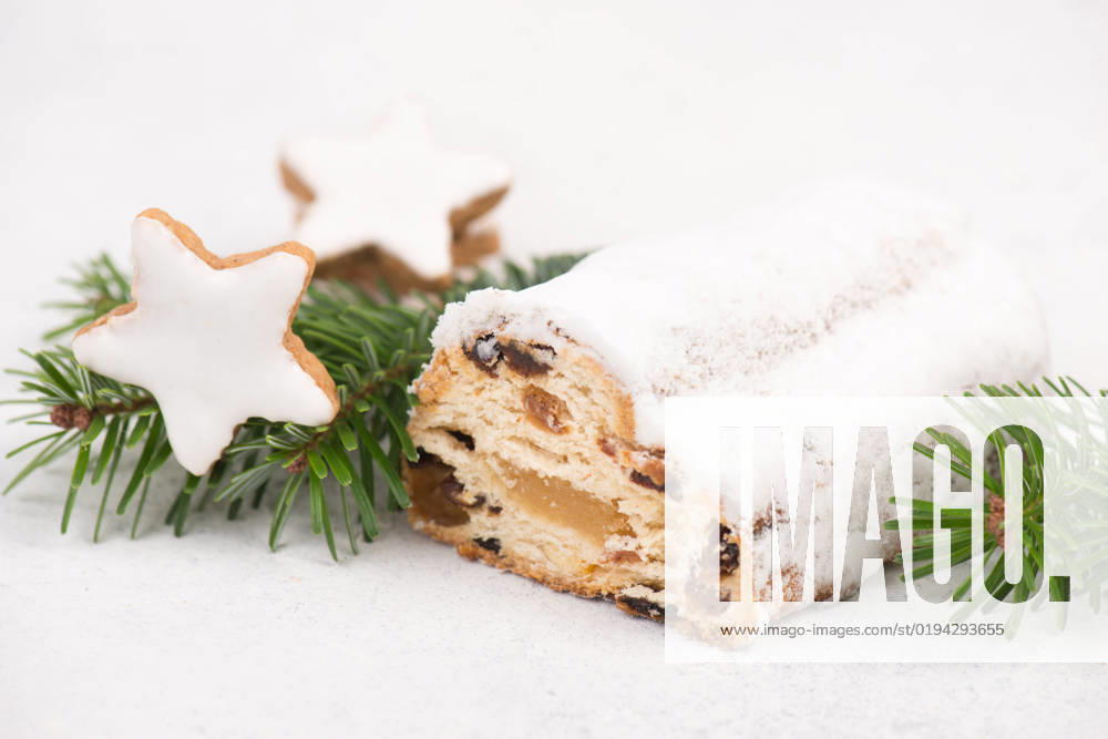 Christstollen, traditonal christmas cake with nuts, raisons, marzipan on a blue background, empty Christstollen, traditonal christmas cake with nuts, raisons, marzipan on a blue background, empty space for text