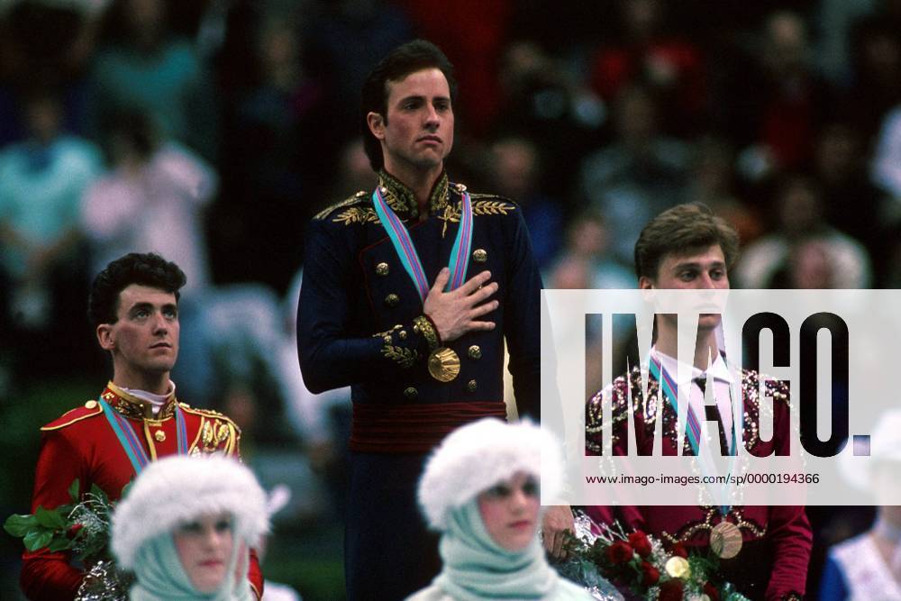OLYMPIC LEGENDS: Brian Boitano Brian Boitano (USA, Mitte) gerührt bei der Hymne seines Landes, daneben Brian Orser (Kanada, li.) und Viktor Petrenko (Sowjetunion) Eiskunstlauf OS Winter Herren Olympische Winterspiele 1988, Olympia, Olympiade, Spiele, Eiskunstlaufen Gruppe Saddledome Calgary