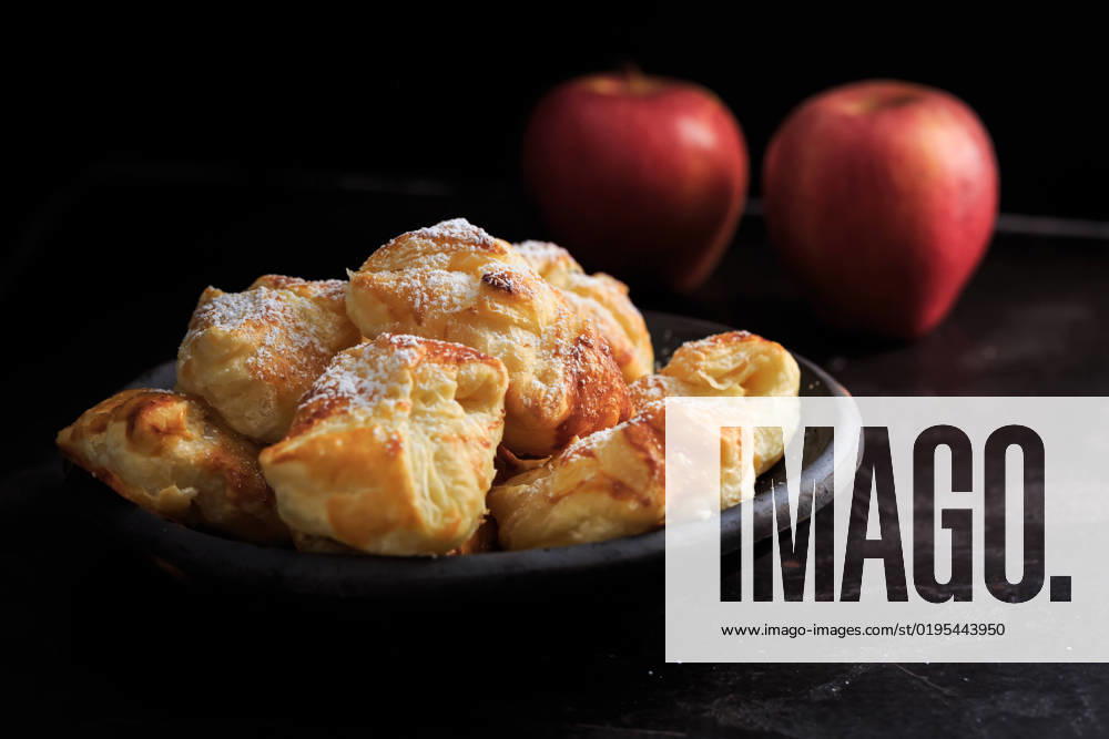 IMAGO Creative, Food, Gebäck, Apfeltaschen Homemade small apple turnovers in bowl on black background Homemade small apple turnovers in bowl on black background