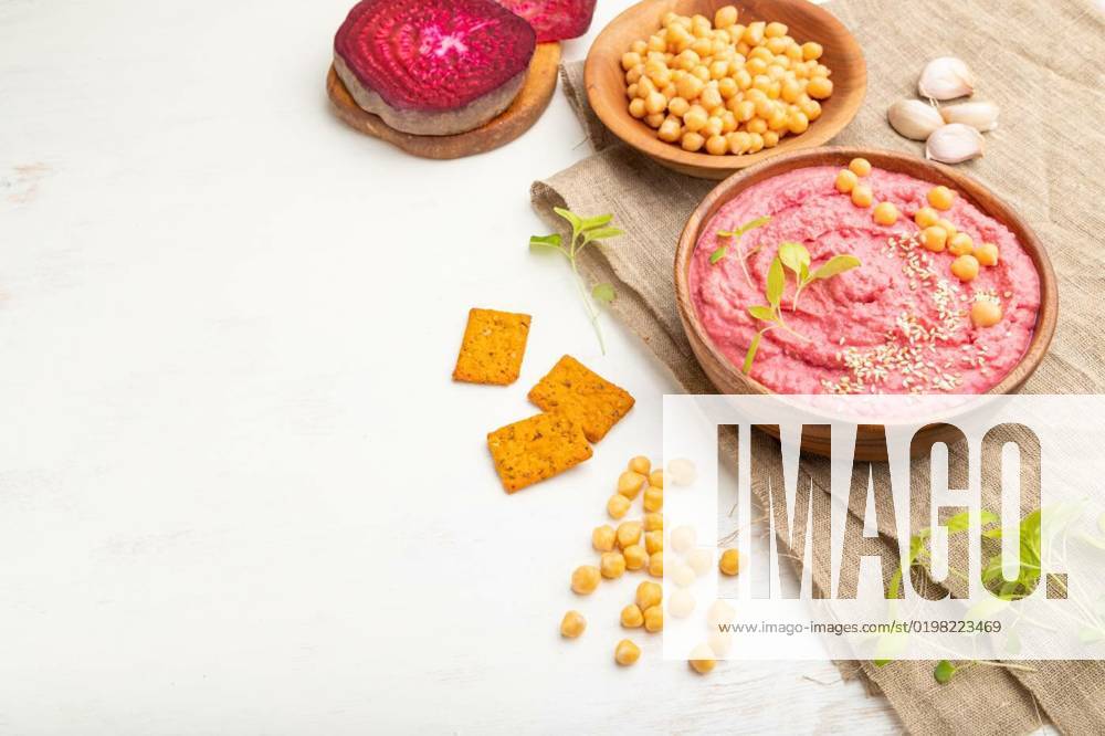 IMAGO Creative, Food, Hummus Hummus with beet and microgreen basil sprouts in wooden bowl on a white wooden background. Side view, copy space., Hummus with beet and microgreen basil sprouts in wooden bowl on a white wooden background and linen textile. Side view, copy space., Hummus with beet and microgreen basil sprouts in wooden bowl on a white wooden background and linen textile. Side view, copy space., 24.10.2022,