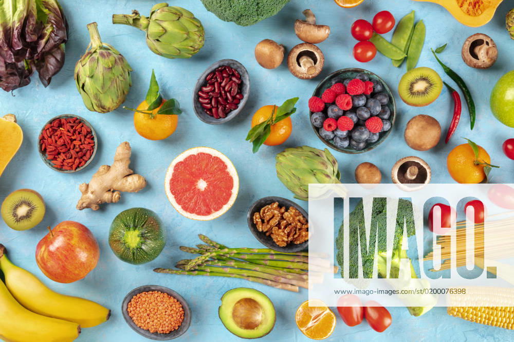 Vegan food. Healthy diet concept. Fruits, vegetables, pasta, nuts, legumes, mushrooms, shot from above on a blue background. A flat lay composition Vegan food. Healthy diet concept. Fruits, vegetables, pasta, nuts, legumes, mushrooms, shot from above on a blue background. A flat lay composition