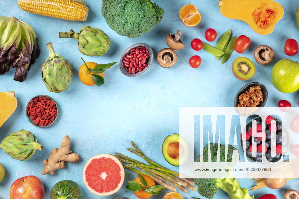 Vegan food. Healthy diet concept. Fruits, vegetables, pasta, nuts, legumes, mushrooms, shot from above on a blue background, forming a frame with a place for text. A flat lay composition Vegan food. Healthy diet concept. Fruits, vegetables, pasta, nuts, legumes, mushrooms, shot from above on a blue background, forming a frame with a place for text. A flat lay composition
