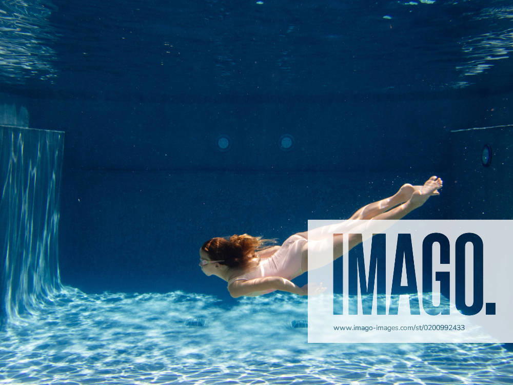 Young girl swims in blue swimming pool in swimsuit and googles Gurnee, Illinois, United States CR_WVNP230125E-1091163-01 ,model released, Symbolfoto