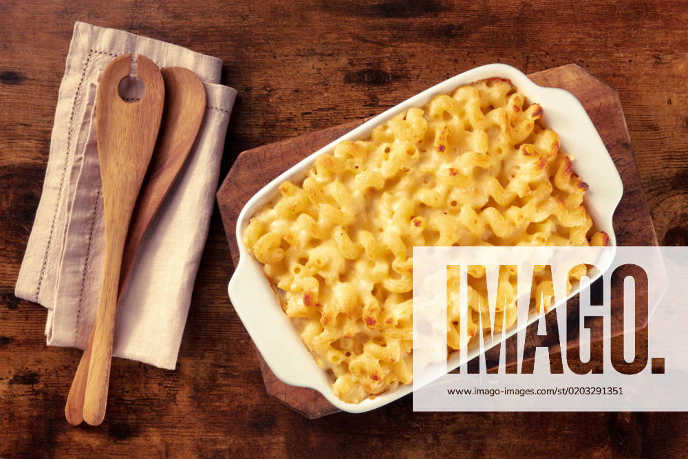 Macaroni and cheese pasta in a casserole, shot from the top Macaroni and cheese pasta in a casserole, shot from the top on a rustic background with wooden spoons