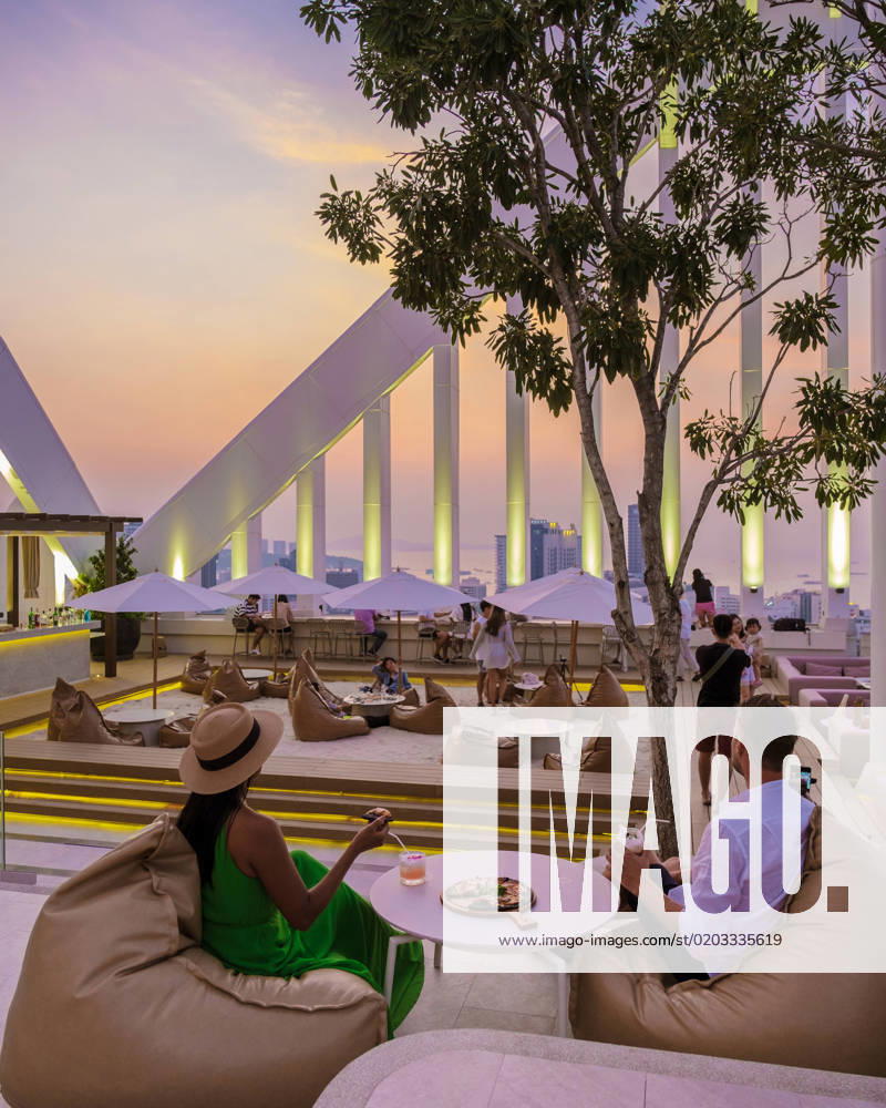 IMAGO Creative, Jahreszeit Sommer, Sommer in der Stadt couple men and women having dinner during sunset at a rooftop restaurant looking out over the city couple of men and women having dinner during sunset at a rooftop restaurant looking out over the city