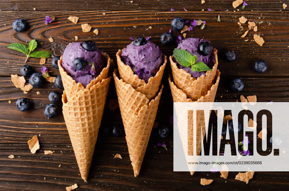 Flat lay view at wafer cones with blackberry icecream on wooden kitchen table Flat lay view at wafer cones with blackberry icecream on wooden kitchen table