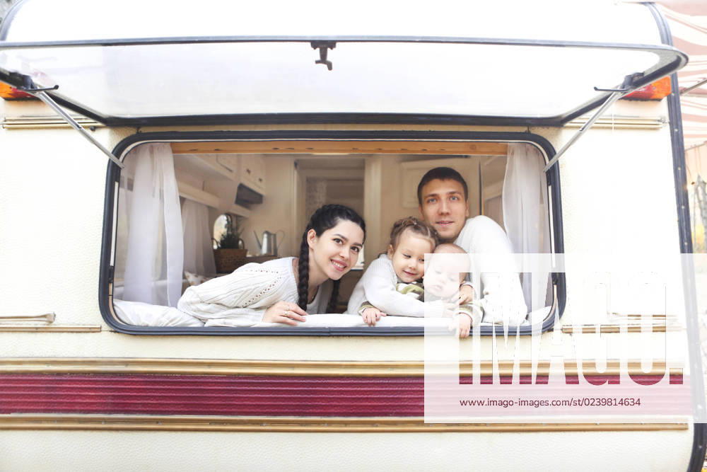 Portrait of the smiling happy family with kids in the house on wheels Portrait of the smiling happy family with kids in the house on wheels indoor ,model released, Symbolfoto