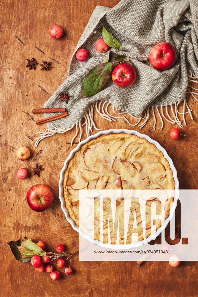 IMAGO Creative, Herbst, Food, Apfelkuchen Homemade apple cake with with sour cream, red apples, Crabapples and cinnamon over wooden background, top view Homemade apple cake with with sour cream, red apples, Crabapples and cinnamon over wooden background, top view.
