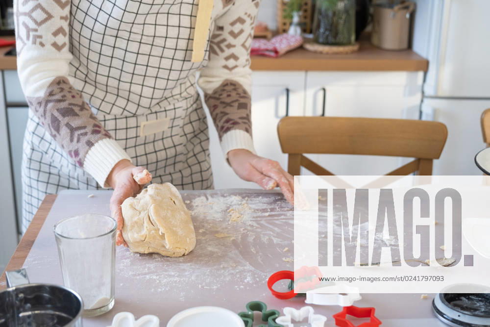 Hands knead thick dough on the kitchen table, decorated with festive decorations for Christmas and New year. Baking at home, aroma and comfort. Close-up Hands knead thick dough on the kitchen table, decorated with festive decorations for Christmas and New year. Baking at home, aroma and comfort. Close-up ,model released, Symbolfoto