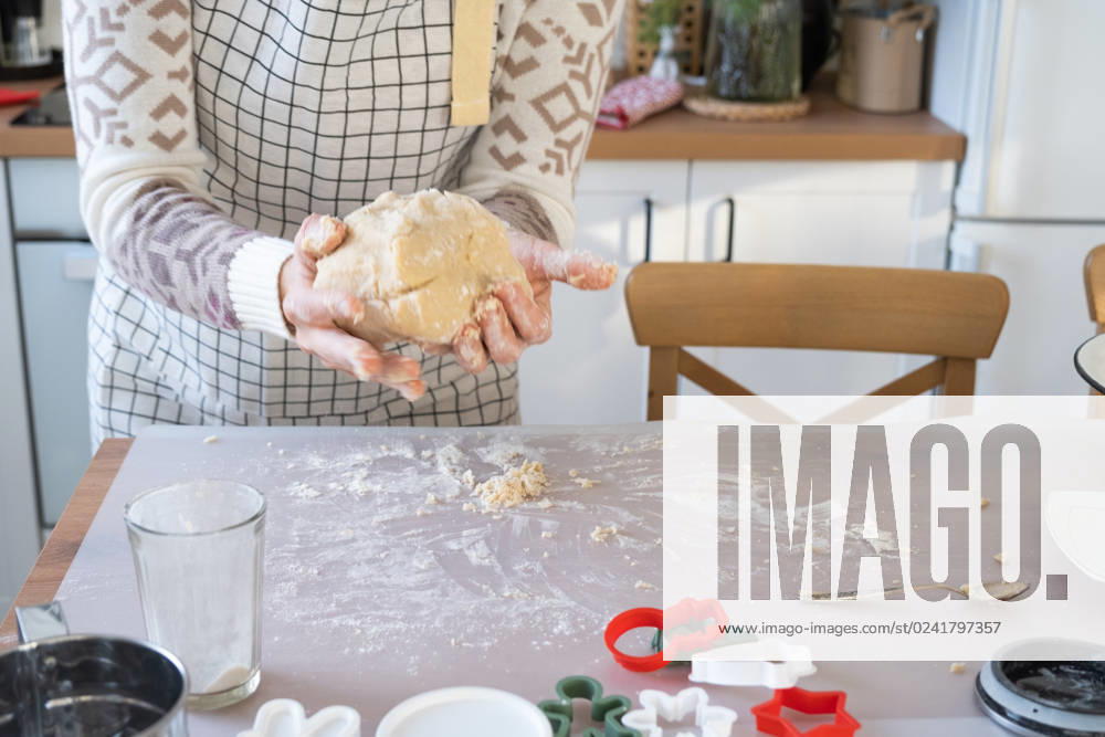 Hands knead thick dough on the kitchen table, decorated with festive decorations for Christmas and New year. Baking at home, aroma and comfort. Close-up Hands knead thick dough on the kitchen table, decorated with festive decorations for Christmas and New year. Baking at home, aroma and comfort. Close-up ,model released, Symbolfoto