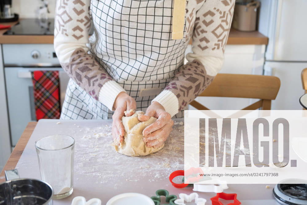 Hands knead thick dough on the kitchen table, decorated with festive decorations for Christmas and New year. Baking at home, aroma and comfort. Close-up Hands knead thick dough on the kitchen table, decorated with festive decorations for Christmas and New year. Baking at home, aroma and comfort. Close-up ,model released, Symbolfoto