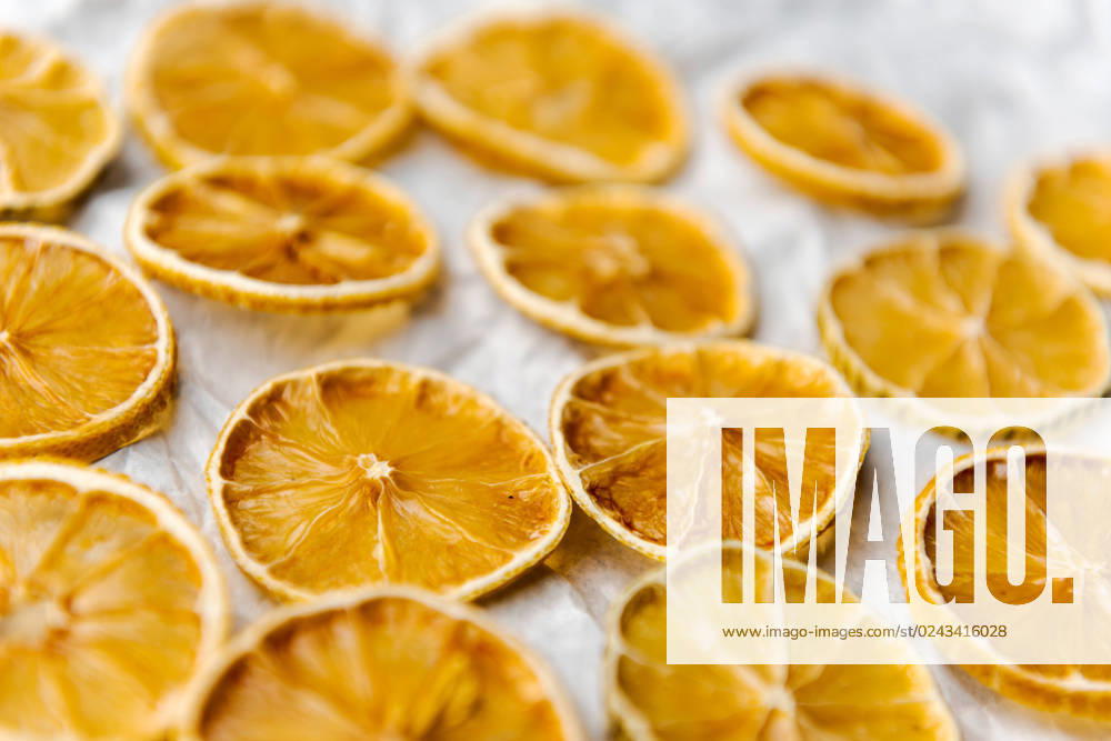 Slices of dried lemon lying on white paper Slices of dried lemon lying on white paper