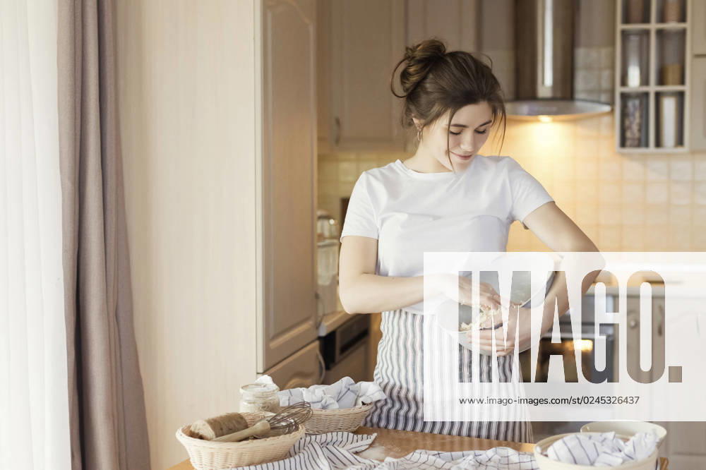 Smiling young woman kneading bread dough in bowl model released, Symbolfoto property released, ONAF00470