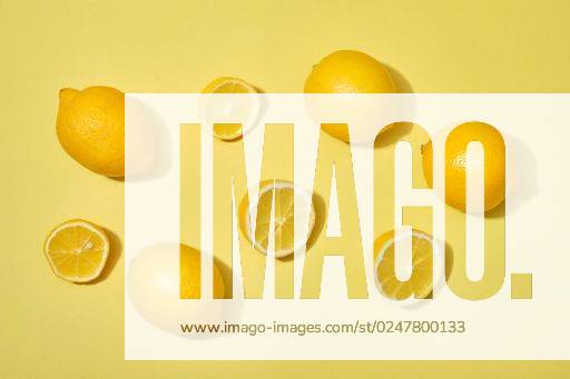 A top view shot of with halves and whole ripe lemons on yellow background *** einer Spitze Ansicht erschossen des mit Hälften und Ganze ripe Zitronen am Gelb Hintergrund 5747101