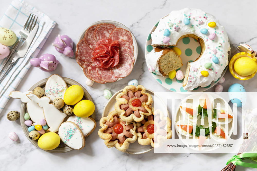 Festive dinner, Easter brunch. Easter table scene with an assortment of baking, desserts, stuffed eggs and dyed eggs on a marble background. View from above. Festive dinner, Easter brunch. Easter table scene with an assortment of baking, desserts, stuffed eggs and dyed eggs on a marble background. View from above.