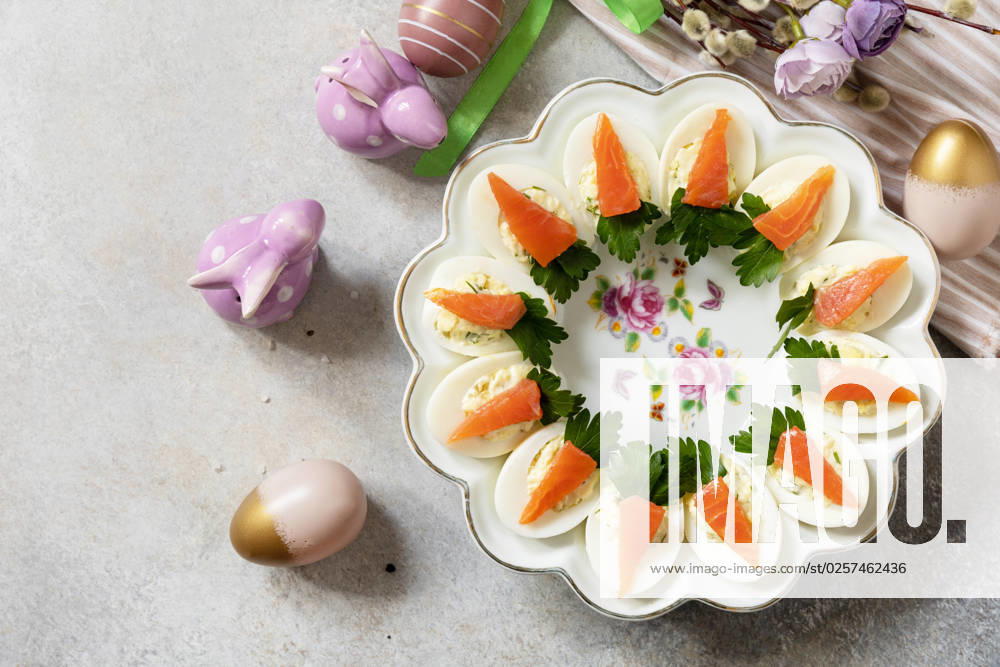 Stuffed eggs with cheese and salted salmon in the form of a carrot. Festive dinner, Easter brunch. View from above. Copy space. Stuffed eggs with cheese and salted salmon in the form of a carrot. Festive dinner, Easter brunch. View from above. Copy space.