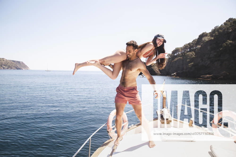 Shirtless man having fun with girlfriend on yacht at vacation model released, Symbolfoto, PCLF00496