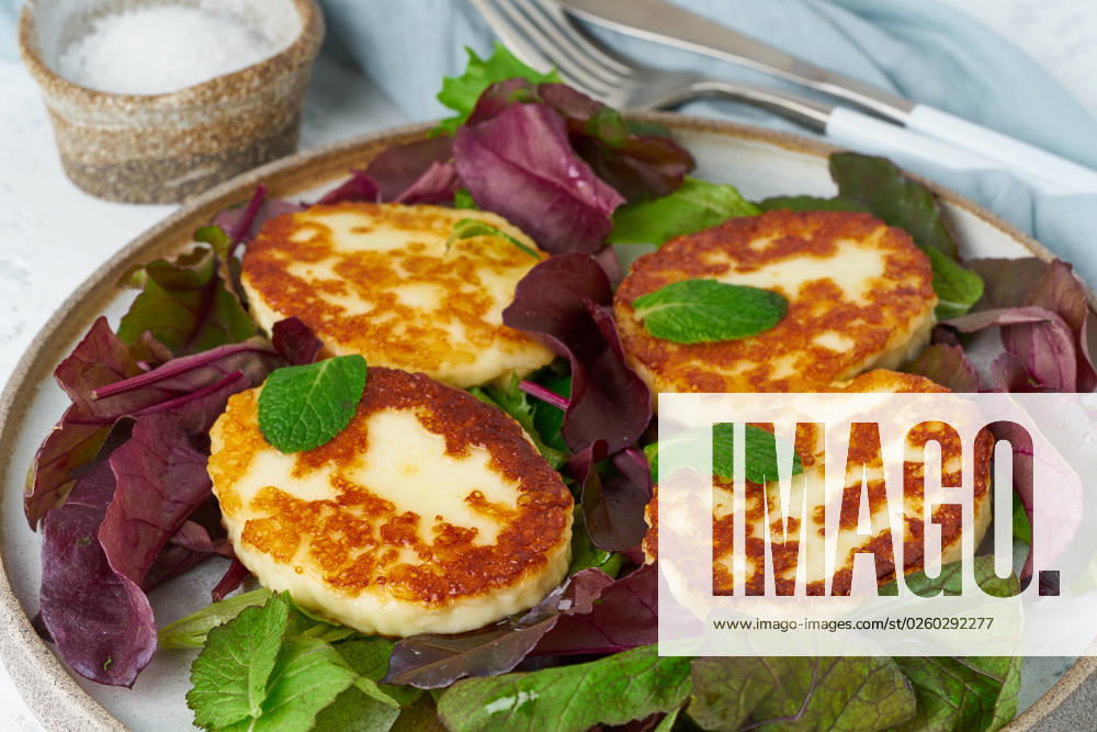 Cyprus roasted halloumi with salad mix, beet tops. Lchf, pegan, fodmap Cyprus roasted halloumi with salad mix, beet tops. Lchf, pegan, fodmap, paleo, scd, keto, ketogenic diet. Balanced food, clean eating recipe. White background, side view