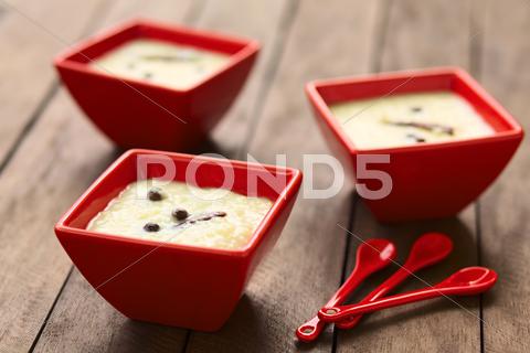 Three red bowls of the ecuadorian dessert called morocho (coarsely ground white corn) cooked with milk, sugar and spices (cinnamon and allspice), similarly to rice pudding (selective focus, focus on the middle of the lower morocho) allspice, bowl, cinnamon, coarse, condiment, cooked, corn, dessert, ecuador, ecuadorian, food, ground, horizontal, jamaica pepper, kernel, maize, milk, morocho, newspice, porridge, prepared, pudding, red, spice, sweet, traditional, white, south, latin, america, american, specialty