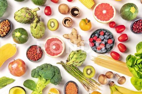 Vegan food. Healthy diet concept. Fruits, vegetables, pasta, nuts, legumes, mushrooms, shot from the top on a white background. A flat lay composition vegan, vegetarian, food, healthy, diet, white, background, fruit, vegetable, pasta, mushrooms, legumes, pulses, overhead, above, view, top, shot, flat, lay, flat lay, flatlay, nuts, table, cooking, kitchen, raw, fresh, nutrition, ingredient, concept, veg, produce, supermarket, organic, vitamin, protein, carbohydrate, fiber, wholesome, natural, superfood, grapefruit, artichoke, broccoli, various, variety, assortment, many, different