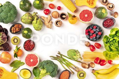 Vegan food. Healthy diet concept. Fruits, vegetables, pasta, nuts, legumes, mushrooms, shot from the top on a white background, forming a frame with a place for text. A flat lay composition vegan, vegetarian, food, healthy, diet, white, background, fruit, vegetable, pasta, mushrooms, legumes, pulses, overhead, above, view, top, shot, flat, lay, flat lay, flatlay, nuts, table, kitchen, raw, fresh, nutrition, ingredient, veg, produce, organic, vitamin, fiber, wholesome, grapefruit, artichoke, broccoli, variety, many, frame, copy, space, copyspace, copy space, place, text, ginger, design, template