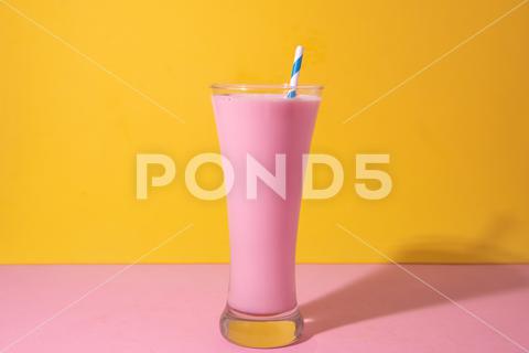 A glass of strawberry smoothie isolated on yellow and pink background fruit, diet, berry, strawberry, drink, healthy, nutrition, food, fresh, blended, vitamin, milkshake, background, summer, smoothie, sweet, dessert, refreshment, juicy, juice, glass, pink, isolated, straw, beverage, horizontal, yellow